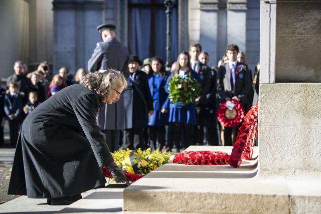 Andrea McKenzie is placing a wreath of poppies on the steps of the white marble Cenotaph.