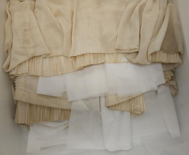 Gown taffeta condition Machine-stitched silk of the original wedding gown’s overskirt and inside pleats showing shattering of the ivory-coloured taffeta.