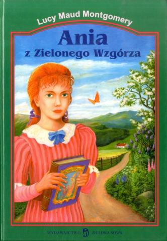 Painted book cover of Ania z Zielonego Wzgórza. Anne is standing in a rural landscape with a book in her hand.