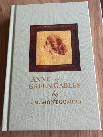 Photo of hardcover book, light emerald colour, title in gold lettering; in the centre, a photo of Anne based on the magazine photo that inspired Montgomery.