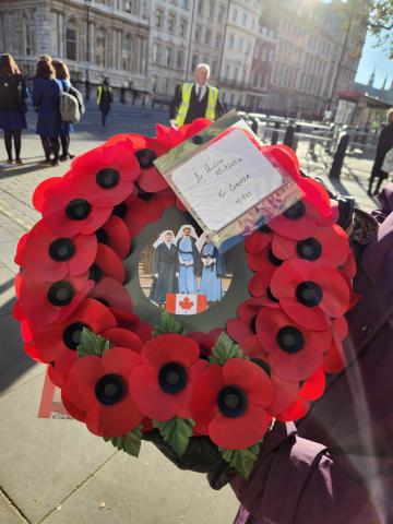 The Canadian wreath of bright-red poppies. The photo at its centre shows Nursing Sisters Guilbride, McNichol, and Mowat in their light-blue working uniforms and white veils.